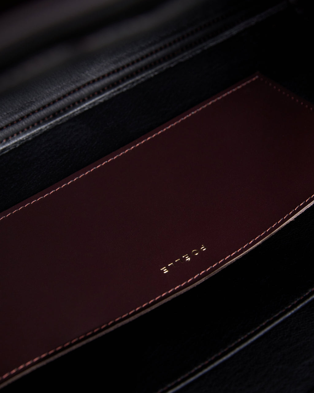 Close-up of the interior pocket detail in a brown leather tote bag by Poelle Atelier