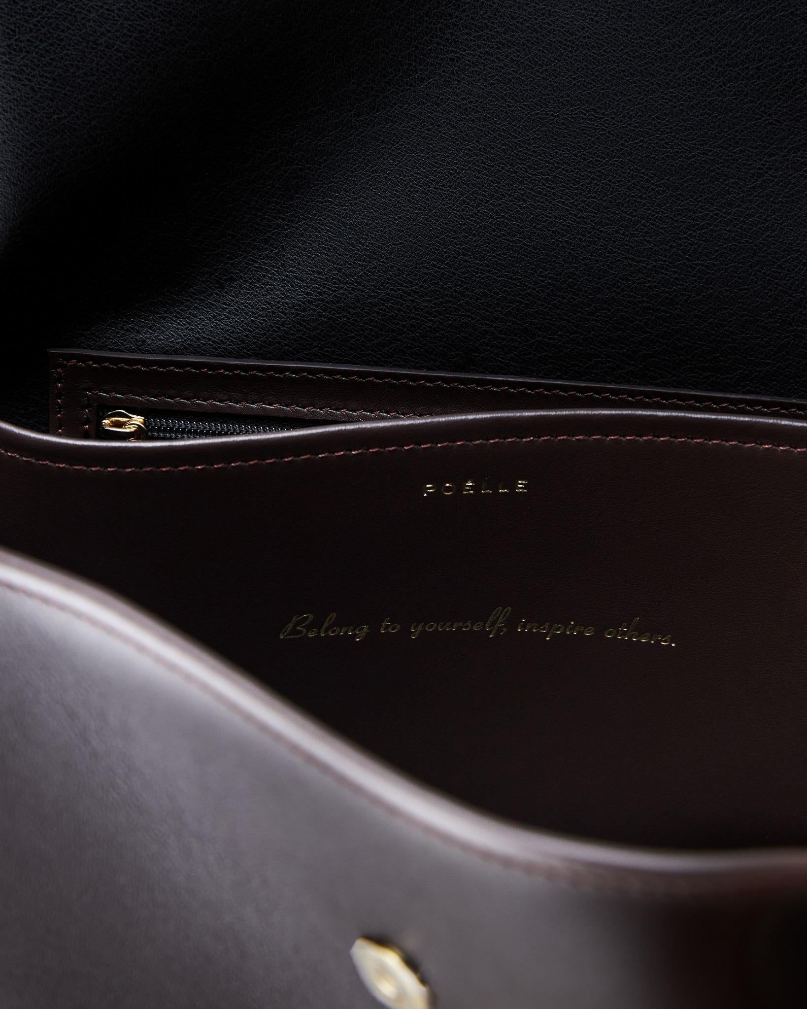 Interior close-up of Poelle Atelier high-end fashion leather bag with zipper pocket and gold embossed logo