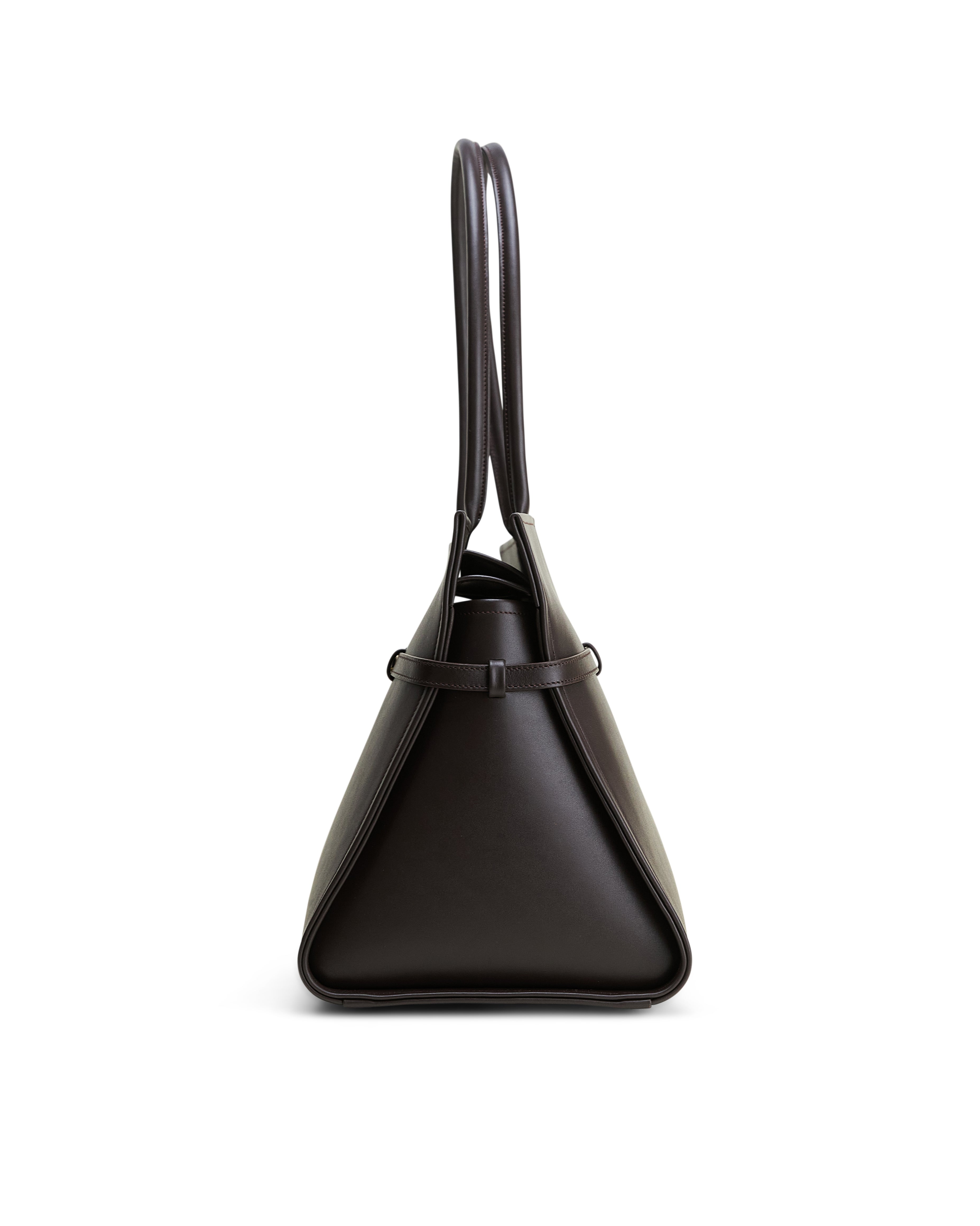 Luxury leather brown bag by Poelle Atelier shown from side with double handles and sleek design