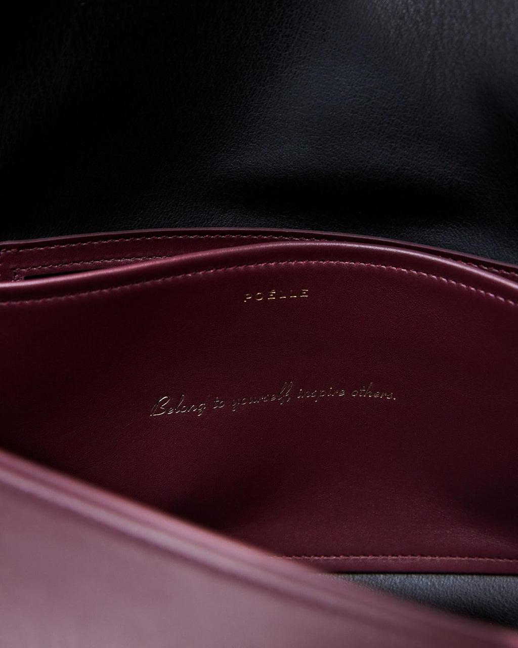 Close-up of Poelle Atelier high-end fashion leather bag interior in burgundy and black leather