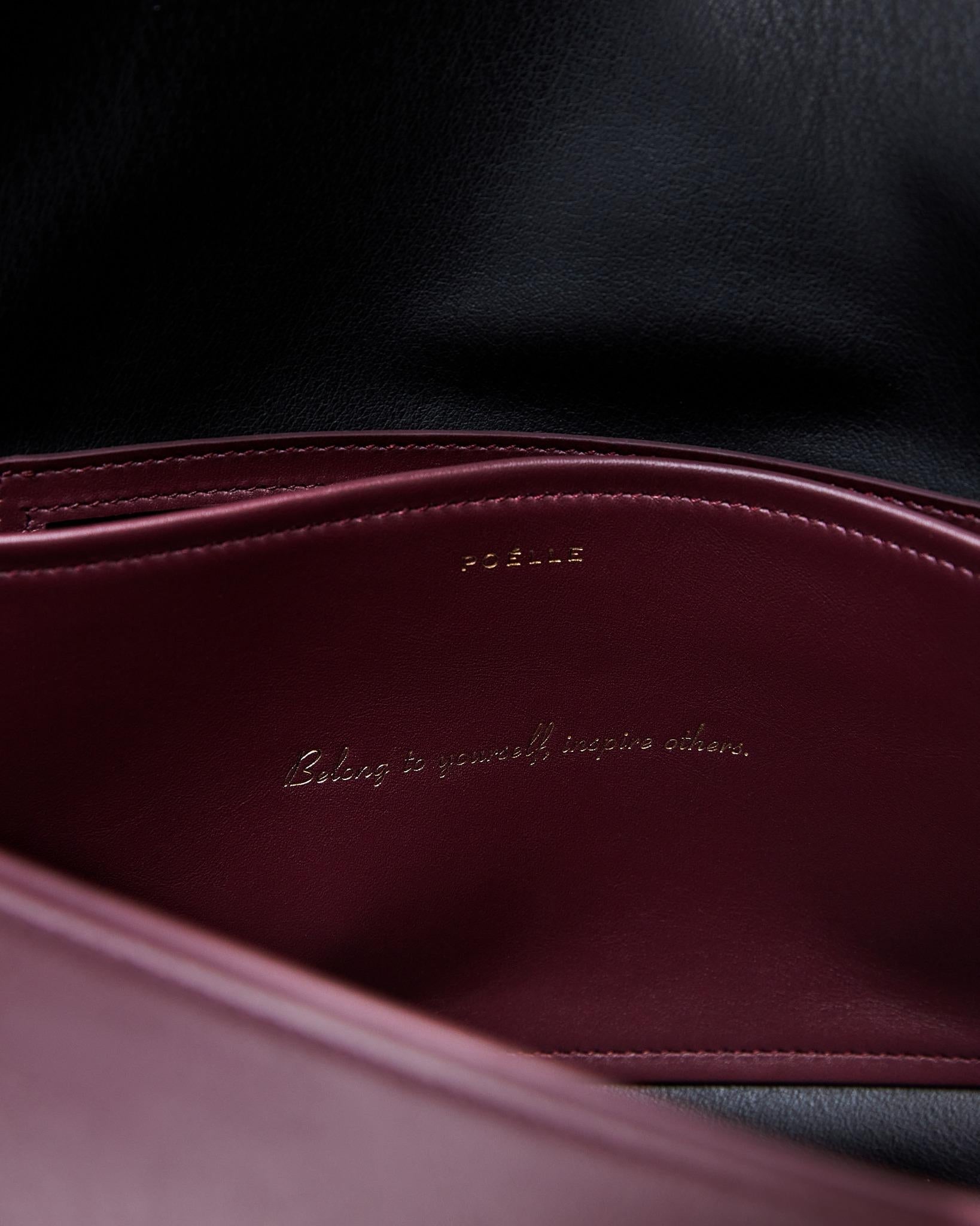Close-up of Poelle Atelier high-end fashion leather bag interior in burgundy and black leather